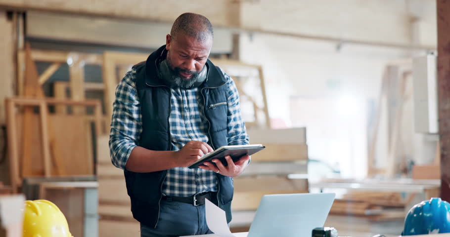 Black man, engineer and workplace with tablet for building ideas, plans and design online. Mature person, work and research as architect in office or startup business for construction project