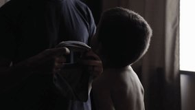 A father dressing his young boy in cinematic slow motion. - Powered by Shutterstock - Get 15% off with code: PIKWIZARD15