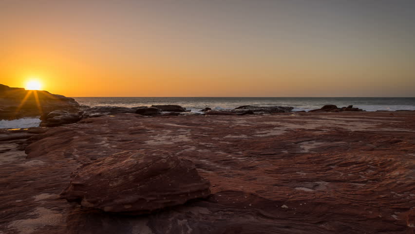 Panning Time lapse of the sun setting over the rocky coast at Mushroom Rock in Kalbarri, Western Australia.