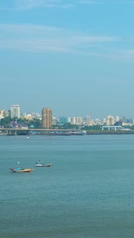 Financial indian capital Mumbai skyline with skyscrappers, fishermen boats and the Bandra Worli Sea Link bridge, called Rajiv Gandhi Sea Link. Bombay, Maharashtra, India. Horizontal camera pan