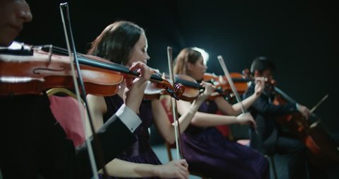 string quartet performs on stage, close-up of violin in work