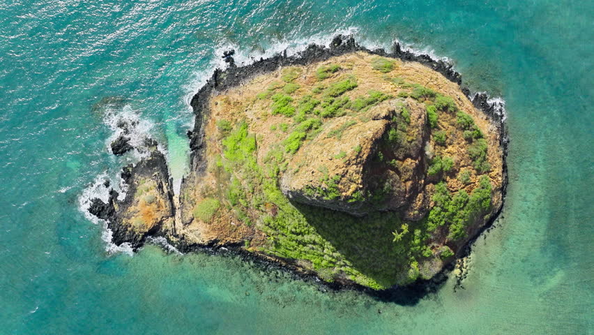 Oahu travel destination USA tourism. Famous landmark island named China man hat. Overhead shot Mokolii volcanic island aerial on sunny summer day.Top down aerial of unique environment on Hawaii island Royalty-Free Stock Footage #3473670375