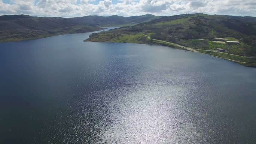 Horizontal pan across rocky valley water storage lake in Australian Alps in summer