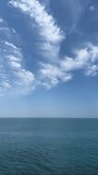 Blue sea and sky clouds, vertical video.