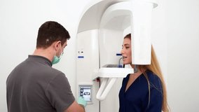 Male radiologist taking teeth x-ray of female patient using dental x-ray machine. Dentist adjusts scan projection by laser guide. Doctor doing digital x-ray tooth scan for woman in the dental clinic. - Powered by Shutterstock - Get 15% off with code: PIKWIZARD15