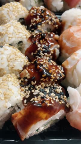 Sushi roll set, rolls with salmon, tuna, eel, shrimp, sesame, closeup, sushi japanese food, seafood, advertising sushi rolls, top view Royalty-Free Stock Footage #3473789063