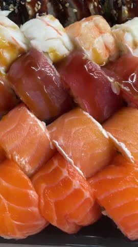 Sushi roll set, rolls with salmon, tuna, eel, shrimp, sesame, closeup, sushi japanese food, seafood, advertising sushi rolls, top view Royalty-Free Stock Footage #3473789377