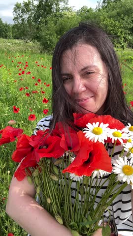 happy woman with field flowers in hands summer day