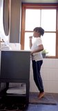 Vertical video of african american boy brushing teeth in bathroom at home, slow motion. Childhood, self care, hygiene and domestic life, unaltered.