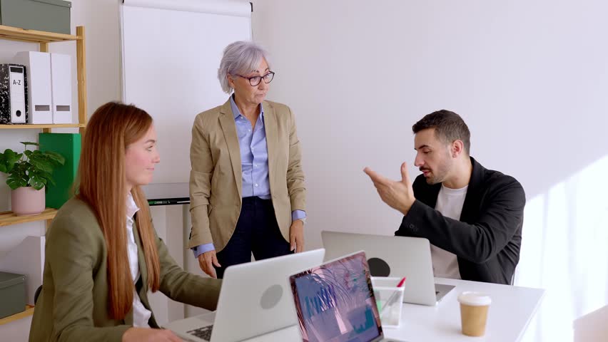Diverse businesspeople working in the office. Teamwork and business concept with diverse group of coworkers using a white board during a brainstorm in a creative process in a meeting room. 