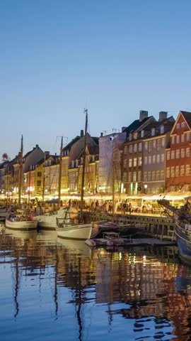 Copenhagen, Denmark Vertical Screen shot. Evening shot of Nyhavn canal (New Harbour) with colorful houses and sailing boats in Copenhagen 