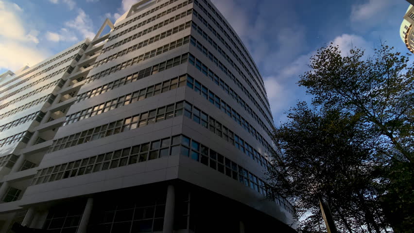 City street with low angle view panning shot of modern architecture in The Hague