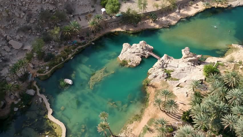 Aerial of amazing Wadi Bani Khalid oasis with turquoise water and palm trees in Oman.