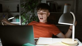 A tired young man studying late at night in his home with laptop and notes, depicting the concept of student life. - Powered by Shutterstock - Get 15% off with code: PIKWIZARD15