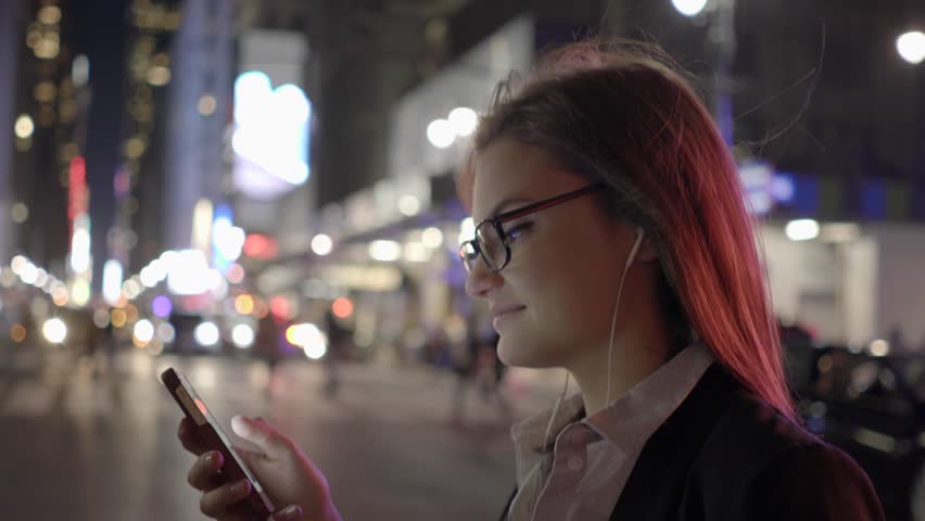 Smart Phone Capturing Her Attention as a Woman Moves through the Streets
