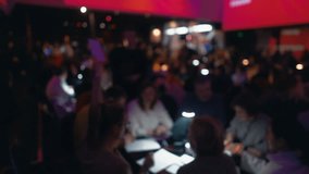 Out-of-focus video offers an ethereal view of friends laughing, drinking, and enjoying the quiz event