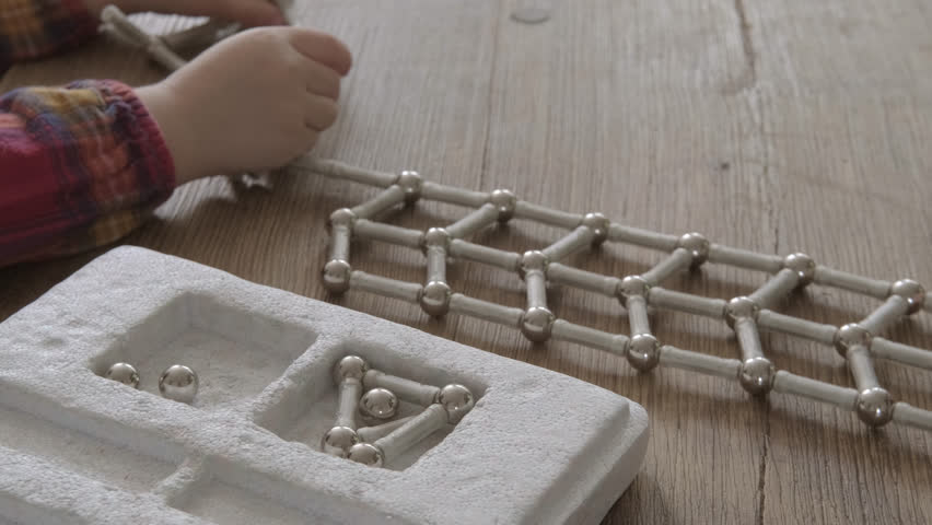 mother and child together assemble structures from magnetic constructor parts, development abstract, spatial thinking, child's imagination, engineering, fine motor skills