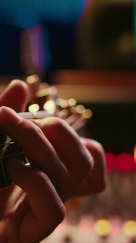 Vertical Video Musician singer recording a new song on his electro acoustic guitar, creating new music in professional studio control room. Artist doing live performance with instrument. Close up