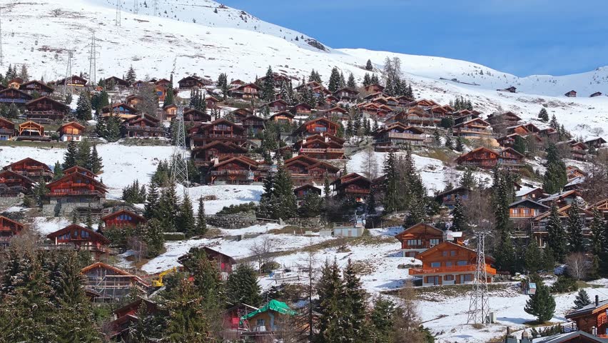 Aerial panoramic view of the Verbier ski resort town in Switzerland. Classic wooden chalet houses standing in front of the mountains. 