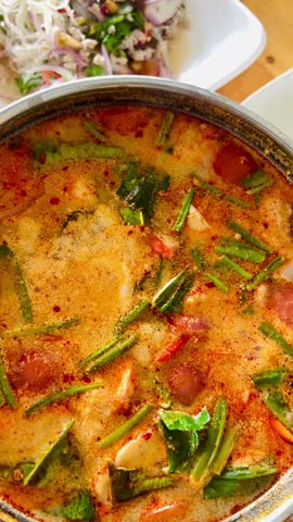 Thai tom yum soup, Thai soup with Seafood, coconut milk and curry Stir-fried Malindjo leaves with egg and dry shrimp, Deep-Fried sea bass with fish sauce served.