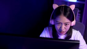 A young Asian woman is playing a game in a private room, stressed out because the game situation is tense because her team is about to lose, Try hard to win the game.