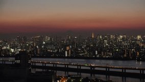 TOKYO, JAPAN : Aerial high angle view of CITYSCAPE of TOKYO and Mount Fuji in sunset. View of buildings around central downtown area. Japanese city life, urban metropolis and nature concept video.