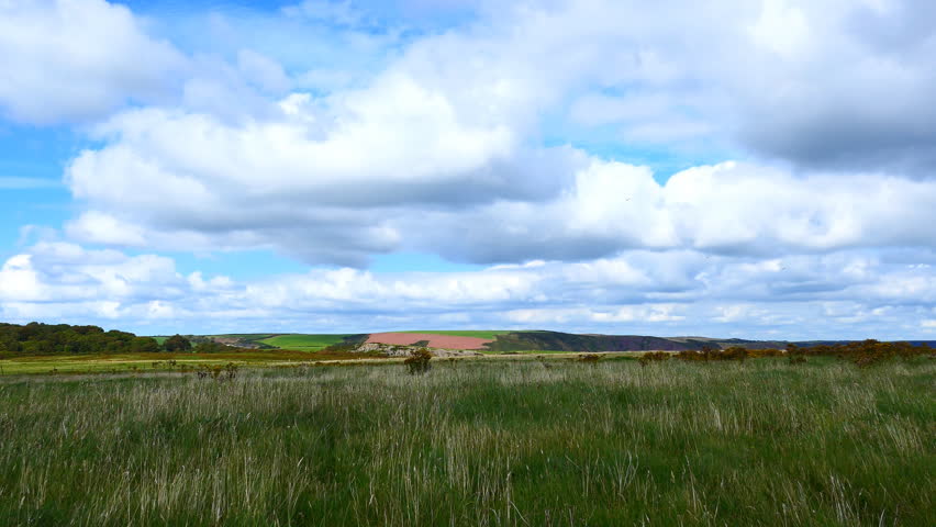 Fluffy clouds over the valley of meadows. Great Britain.