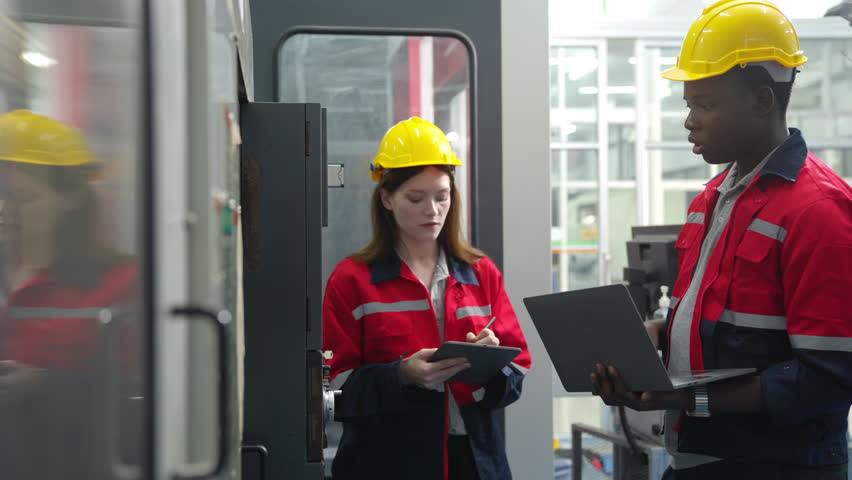 Manufacturing industry factory manufacturing technology concept. Professional man and woman engineer worker in safety wear working and maintaining control CNC lathe machine system in factory room. Royalty-Free Stock Footage #3474558863