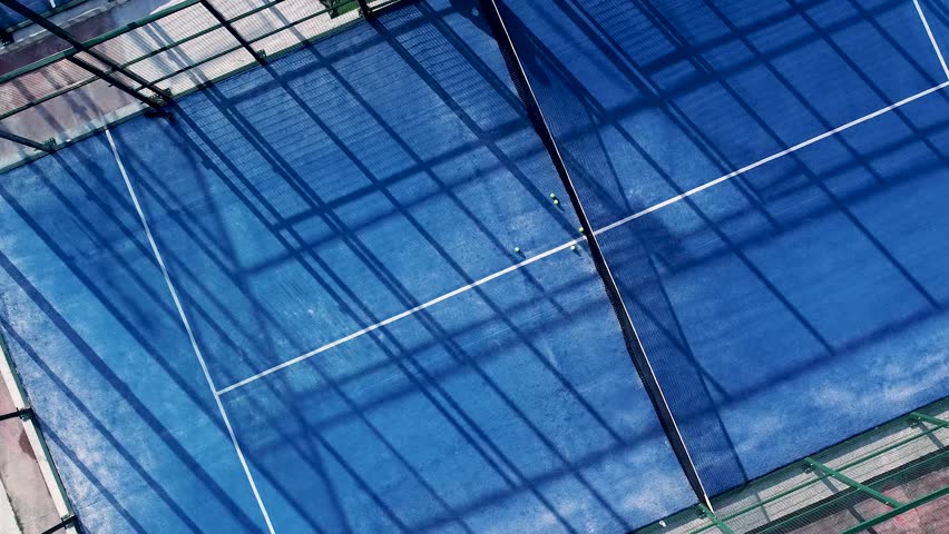 downward drone video footage on a blue paddle tennis court, sports courts concept