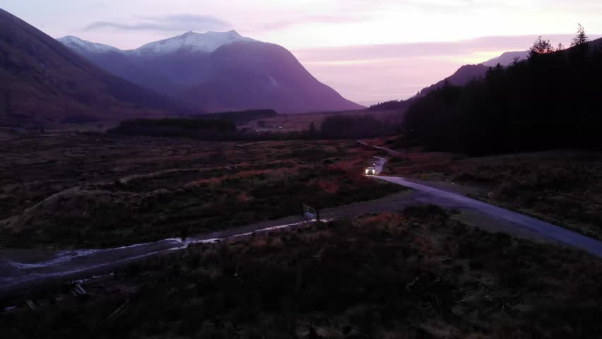 Aerial view of van driving on a road in Glen Etive at night in Highlands, Scotland