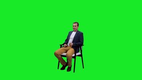 Podcast with young adult male vlogger sitting in chair on green background, Chroma key, 4k pre-keyed footage - Powered by Shutterstock - Get 15% off with code: PIKWIZARD15
