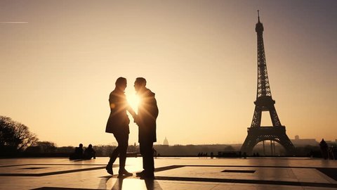 happy affectionate couple in Paris near Eiffel tower, silhouettes of man and woman on honeymoon in Europe