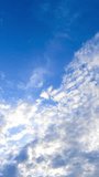 Light beautiful clouds flying along the blue sky. The skies cleaning from the cloudscape. Low angle view timelapse. Vertical video