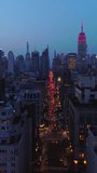 Twilight time in beautiful New York. Lots of cars crossing the city. Dazzling skyscrapers in lights at the backdrop. Vertical video