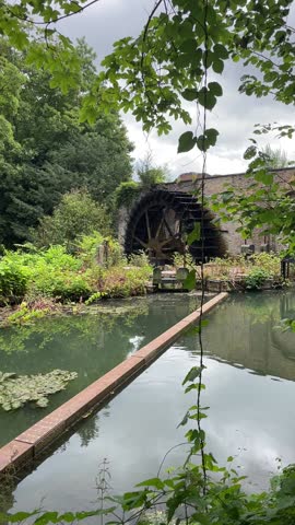 ancient mill wheel rotates under the pressure of a flowing river, makes a characteristic sound, a beautiful landscape in the forest,. High quality FullHD footage