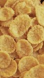 Group of cornflakes in rotation close up. Vertical video.