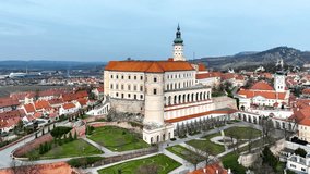 Mikulov castle in South Moravia, Czech Republic. Build  on a rock. Originally medieval, reconstructed in 18th century and renovated in 1950s. Aerial 4 K video with arcades, garden and town