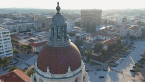 orbit aerial footage of the bell tower at city hall with office buildings, shops and apartments in the city skyline in Pasadena California USA