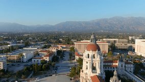aerial footage of the office buildings, shops and apartments in the city skyline at city hall with mountains and lush green trees in Pasadena California USA