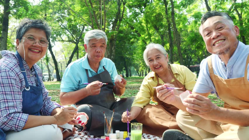 Group asian elderly people join recreation together to do activities and show their talents holiday in the park creative ideas designs paint colorful plaster relax make you feel good and healthy.