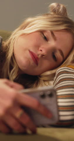 Sad, depression and woman with phone in home reading breakup text, message and notification. Mental health, bedroom and emotional person on smartphone for social media, communication and contact