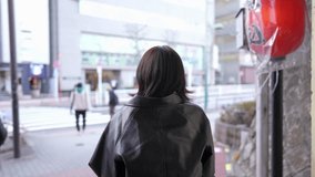 Slow-motion video of a Japanese woman walking around Gotanda Station, Shinagawa-ku, Tokyo in winter