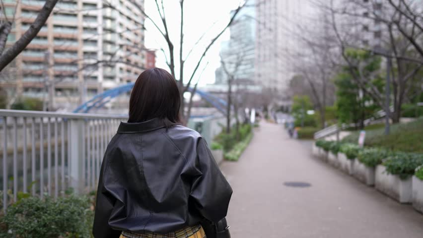Slow-motion video of a Japanese woman walking around Gotanda Station, Shinagawa-ku, Tokyo in winter