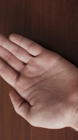 Man shaking food supplements into hand. Yellow softgel capsules Omega-3. Vertical video.
