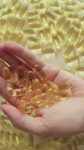 Man hands holding omega 3 capsules. Treatment with dietary supplements concept. Vertical video.