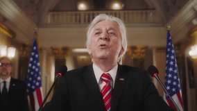 Senior President of America finishes inspirational political speech during press conference in the White House. Positive politician or minister gestures and poses on cameras for media. Slow motion. - Powered by Shutterstock - Get 15% off with code: PIKWIZARD15