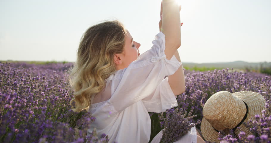 Graceful Young Woman Performing Skincare Ritual in a Lavender Field Royalty-Free Stock Footage #3475280157