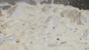 Sauce cooking for spaghetti and pasta. Boiling creamy white sauce for pasta in pan. Close-up yogurt sauce boiling in a pan. Food preparation. Slow motion 100fps.