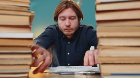 Exhausted businessman moving stacks of books and reviewing documents reports while drinking coffee working hard in home office. Stressed tired freelancer touching head in despair looking at papers. - Powered by Shutterstock - Get 15% off with code: PIKWIZARD15