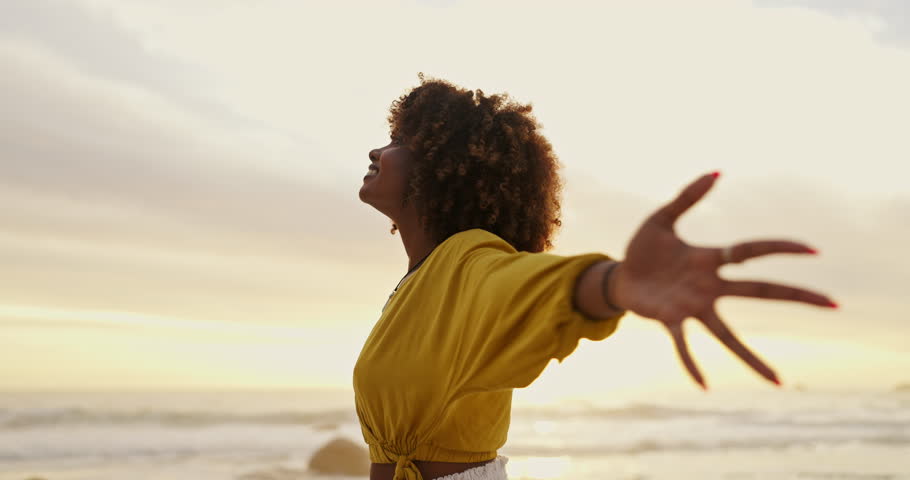 Black woman, sunset and beach with breeze or freedom for travel, holiday and vacation. Female person, sunrise and ocean with fresh air for calm, happiness and peace after new years eve celebration